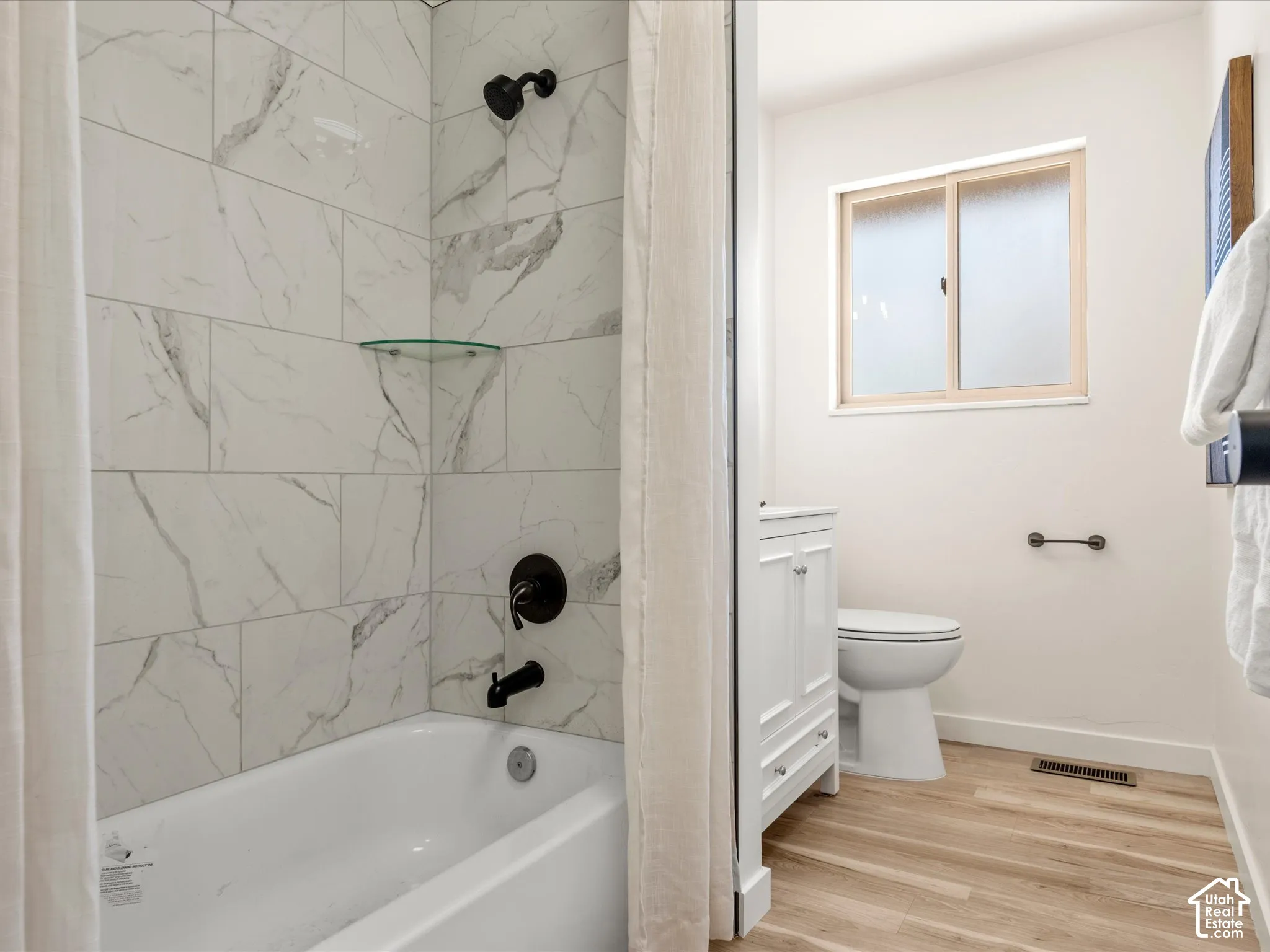 Main Bathroom. White subway tile shower surround with a glass shelf and matte black fixtures