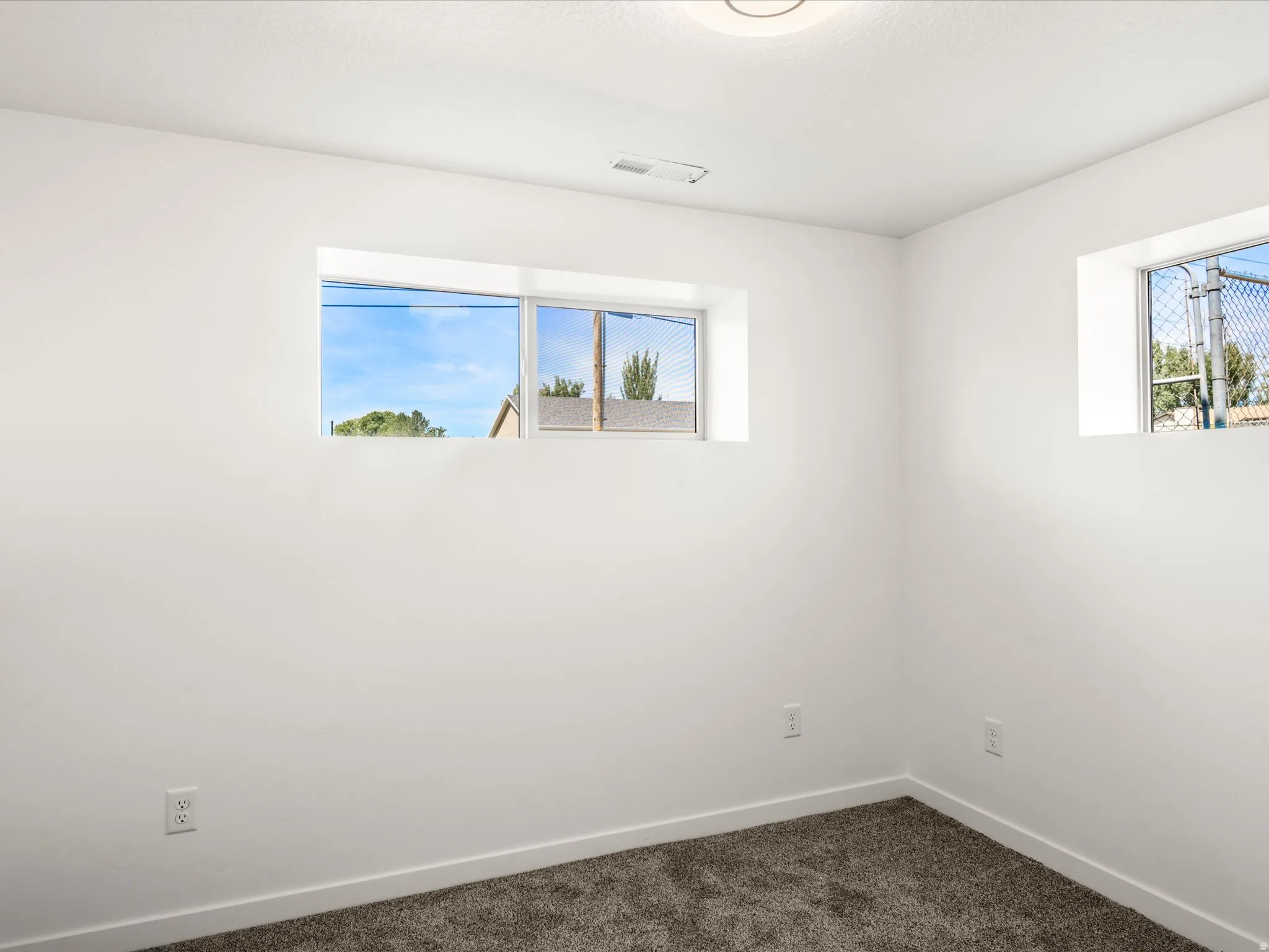 Bedroom #3 Downstairs. Recessed windows, neutral wall color, overhead lighting, and carpet flooring
