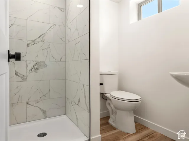 Basement Bathroom. Walk-in shower with white tile surround, glass enclosure, and matte black hardware