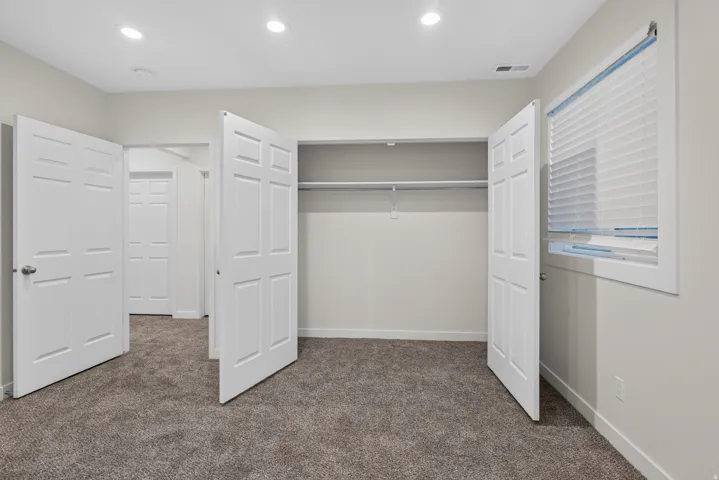 Neutral-toned carpeting with recessed lighting