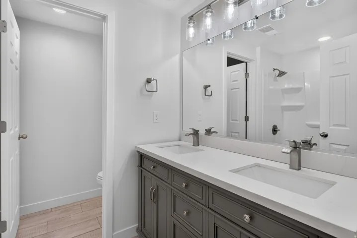Double vanity with gray cabinetry and white countertops