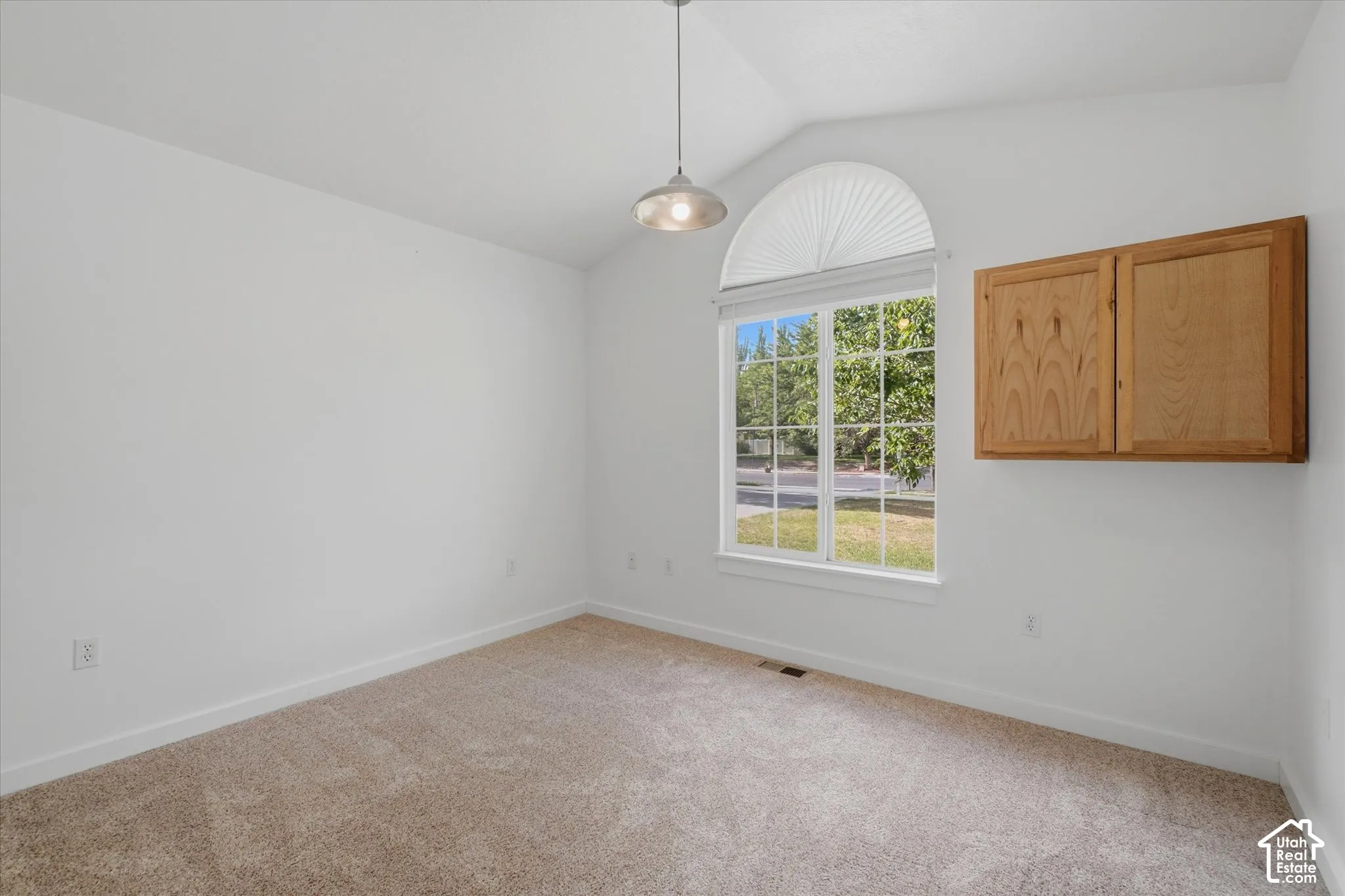 Bright corner room with abundant natural light from arched transom window and multi-pane glass doors