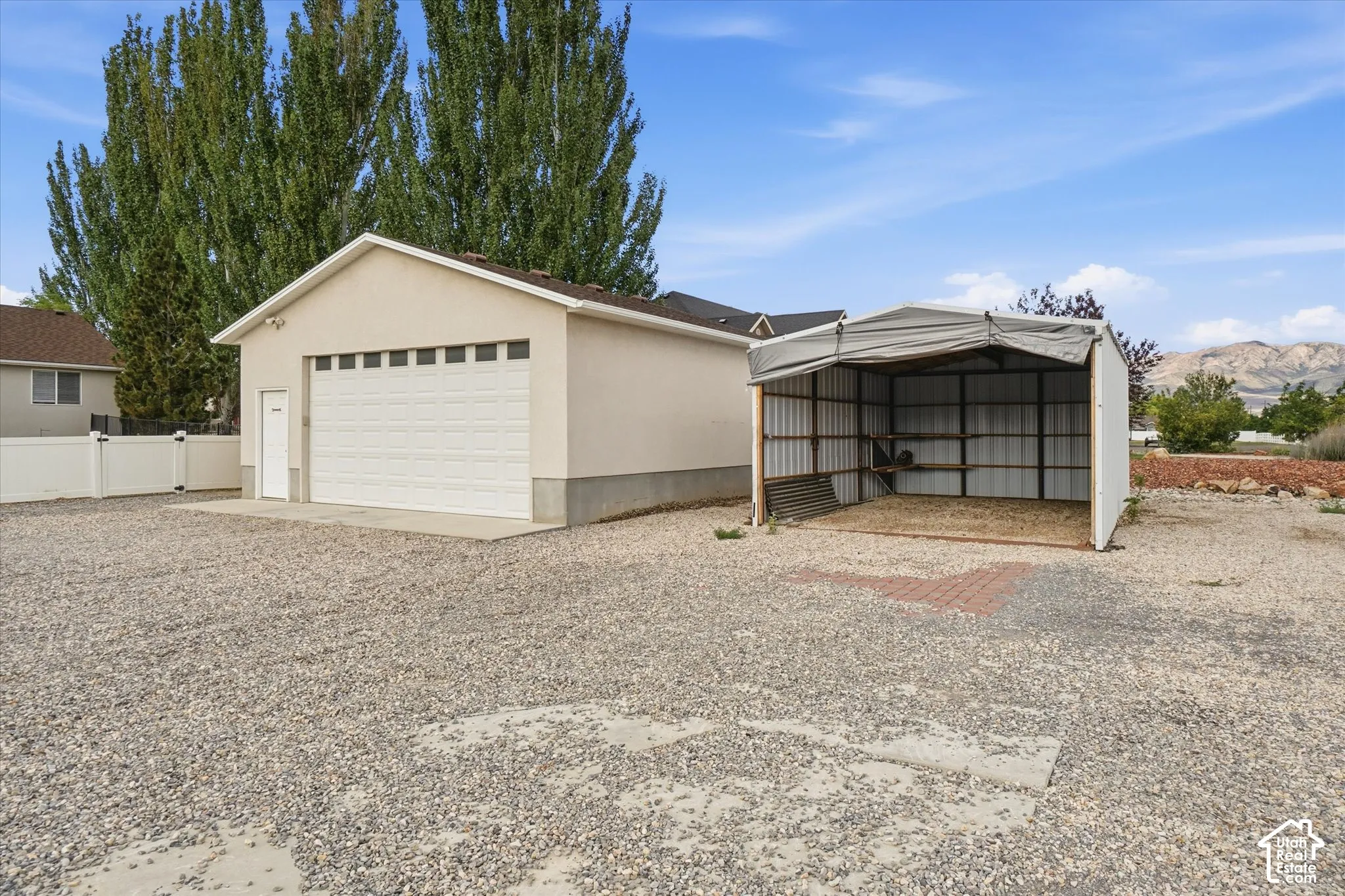 Detached garage with a paneled door, dedicated side entry, and concrete pad