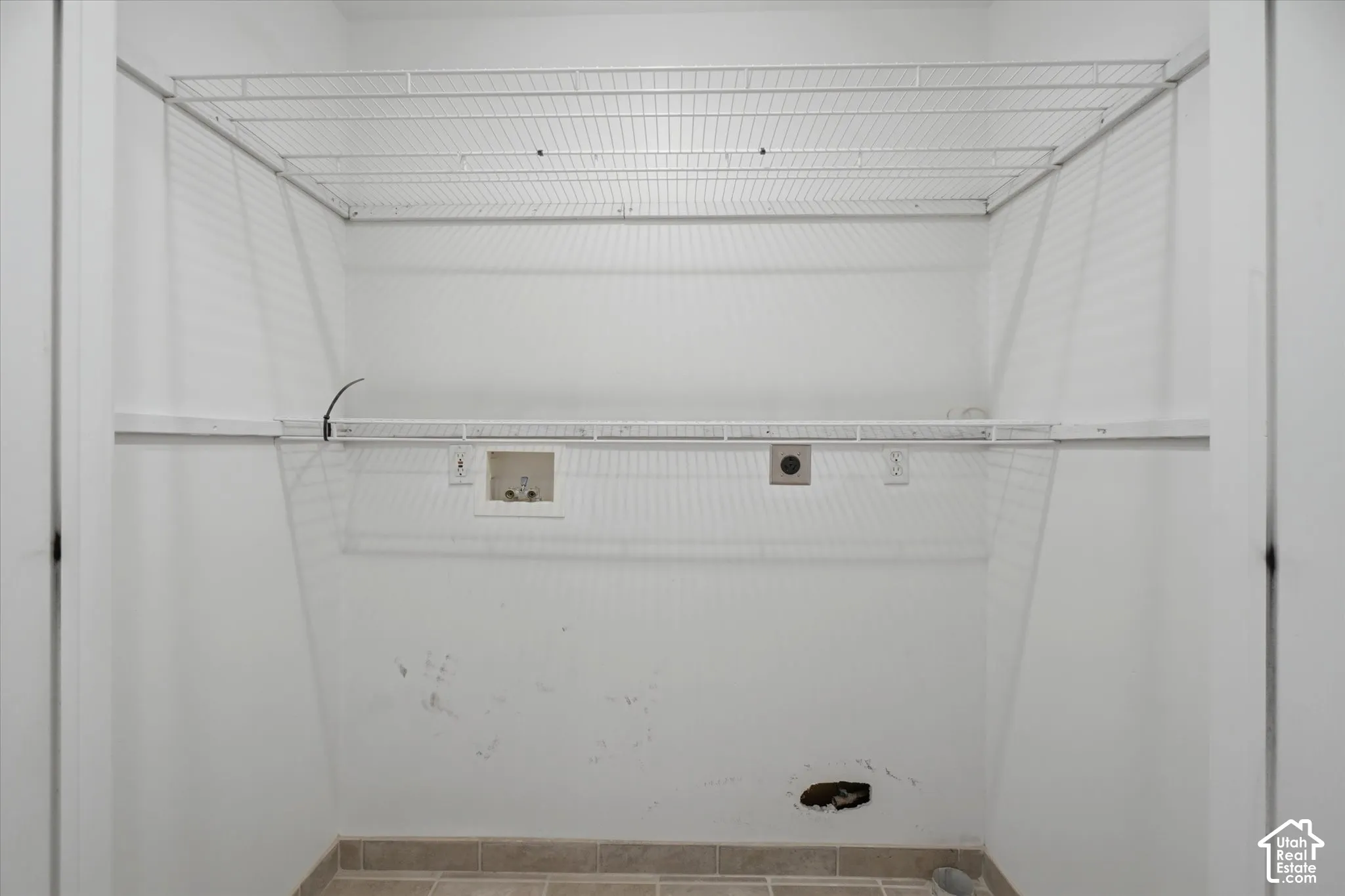 Laundry area with wire shelving, wall hookups, and tiled flooring