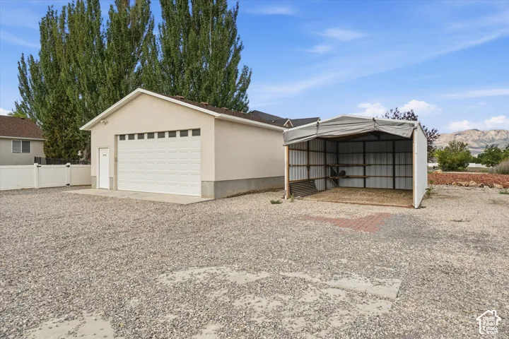 Detached garage with a paneled door, dedicated side entry, and concrete pad