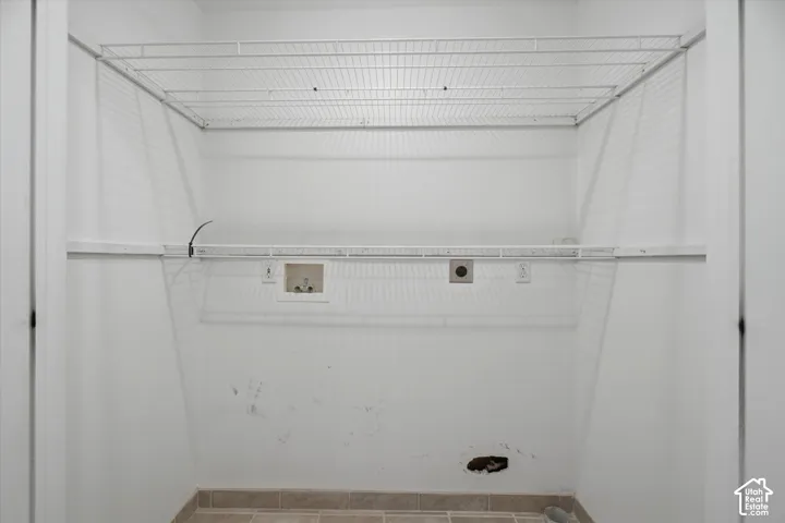 Laundry area with wire shelving, wall hookups, and tiled flooring
