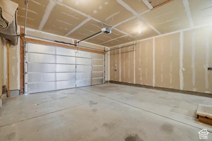 Spacious garage with an automatic overhead door and a concrete floor