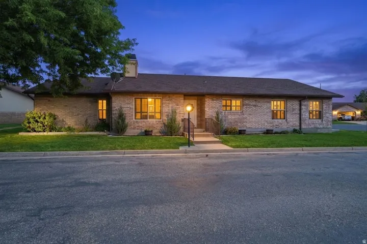 Brick exterior with a dark shingle roof, concrete walkway, and a prominent front door entry