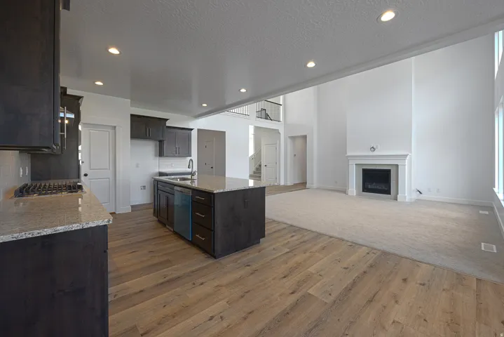 Kitchen featuring dark wood cabinetry, granite countertops, and wood-finish flooring