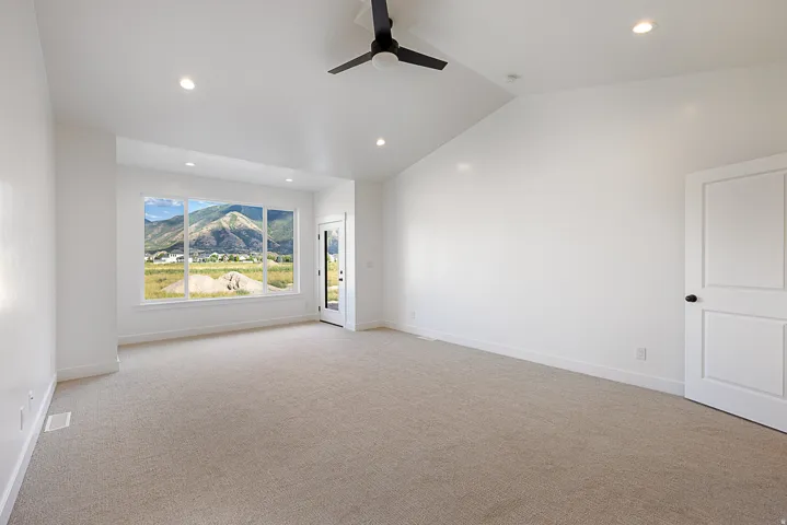 Vaulted ceiling with recessed lighting and a black ceiling fan, large picture windows, and a glass-paneled door