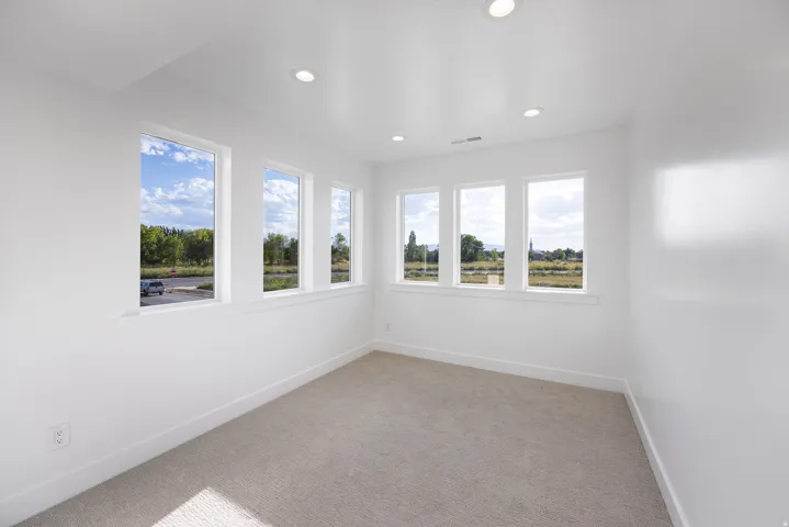 Recessed lighting, multiple windows, plush carpet, white walls, and a white trim