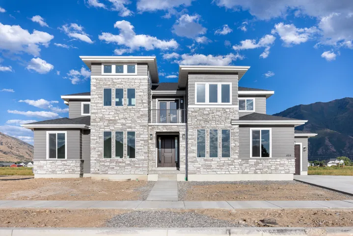 Contemporary exterior with stacked stone and horizontal siding, multiple windows, and a dark entry door