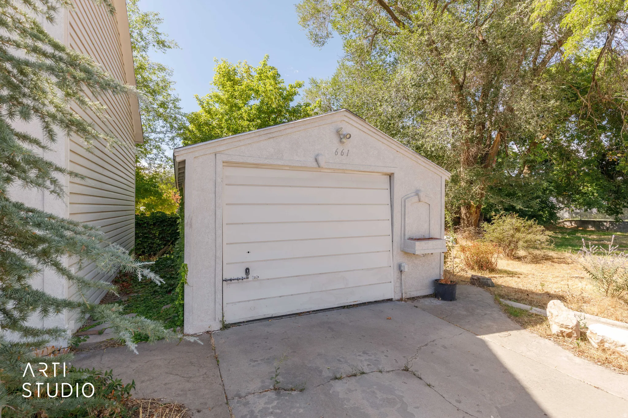 Detached garage with a paneled door and stucco exterior