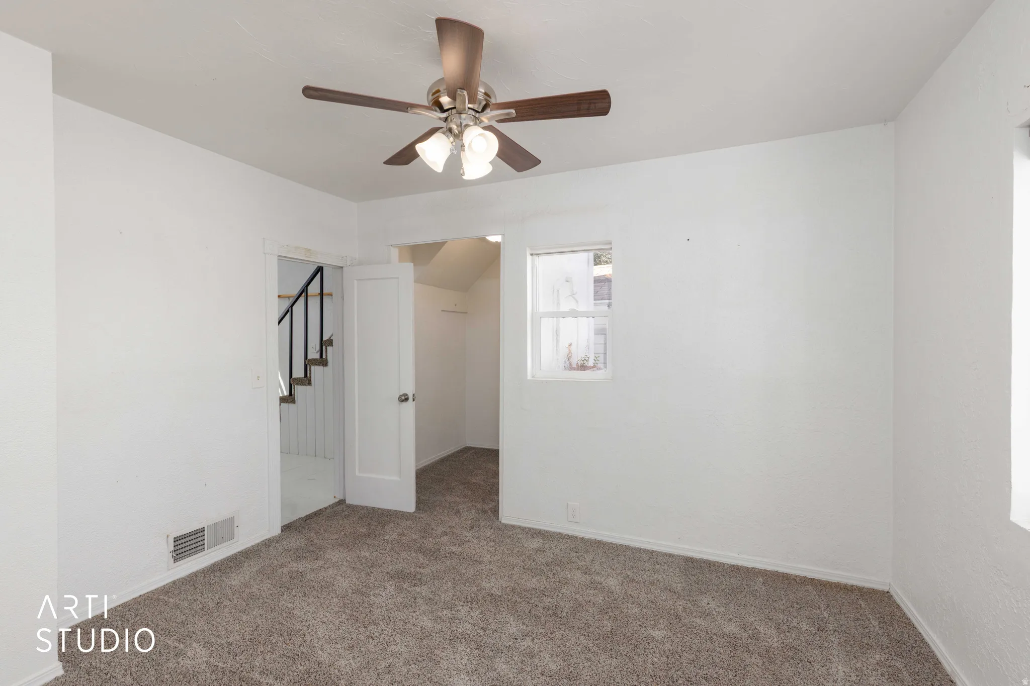 Neutral wall paint, carpet flooring, a ceiling fan with integrated lighting, and a single window