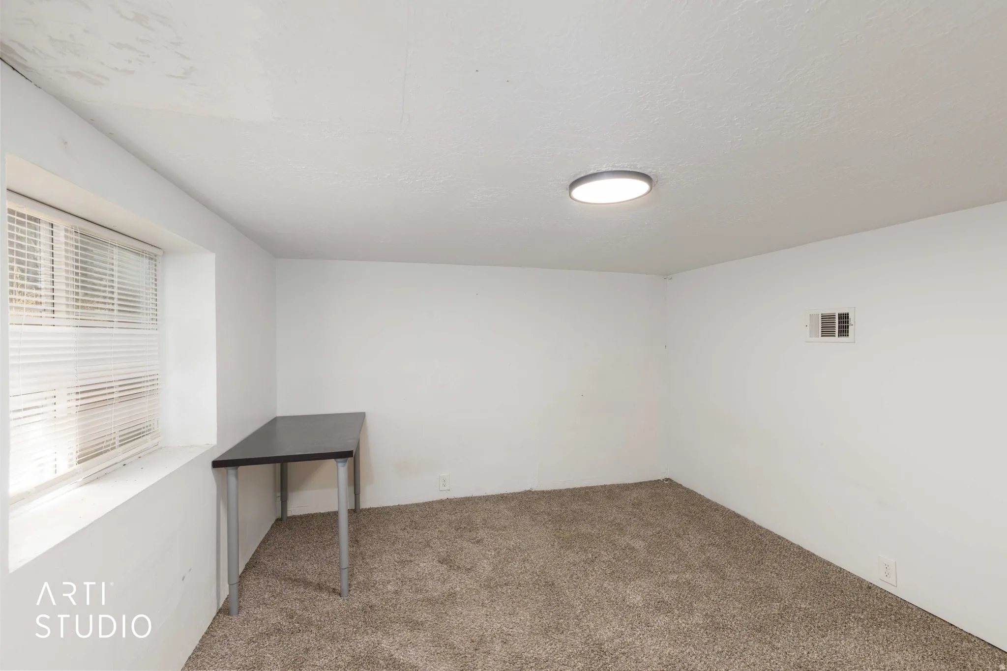 Recessed window with horizontal blinds, overhead flush mount lighting, textured ceilings, white walls, and neutral-toned carpeting