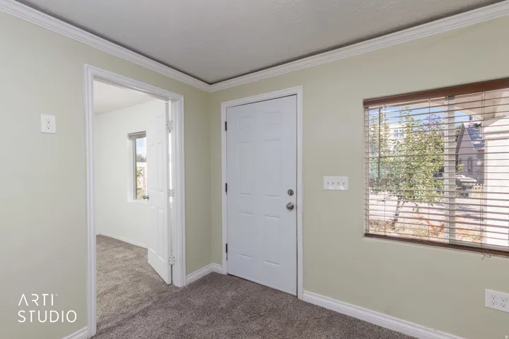 Neutral wall paint, white trim, crown molding, and textured carpeting