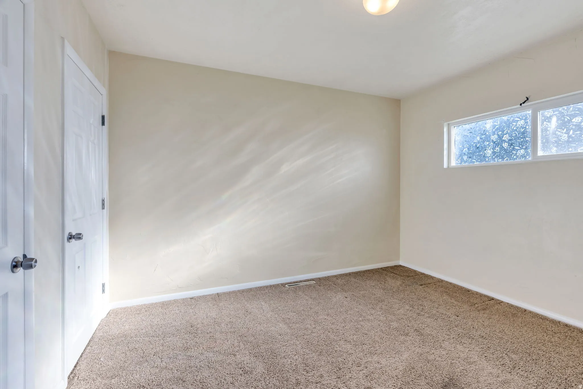 Neutral tone wall paint, textured carpet flooring, white trim