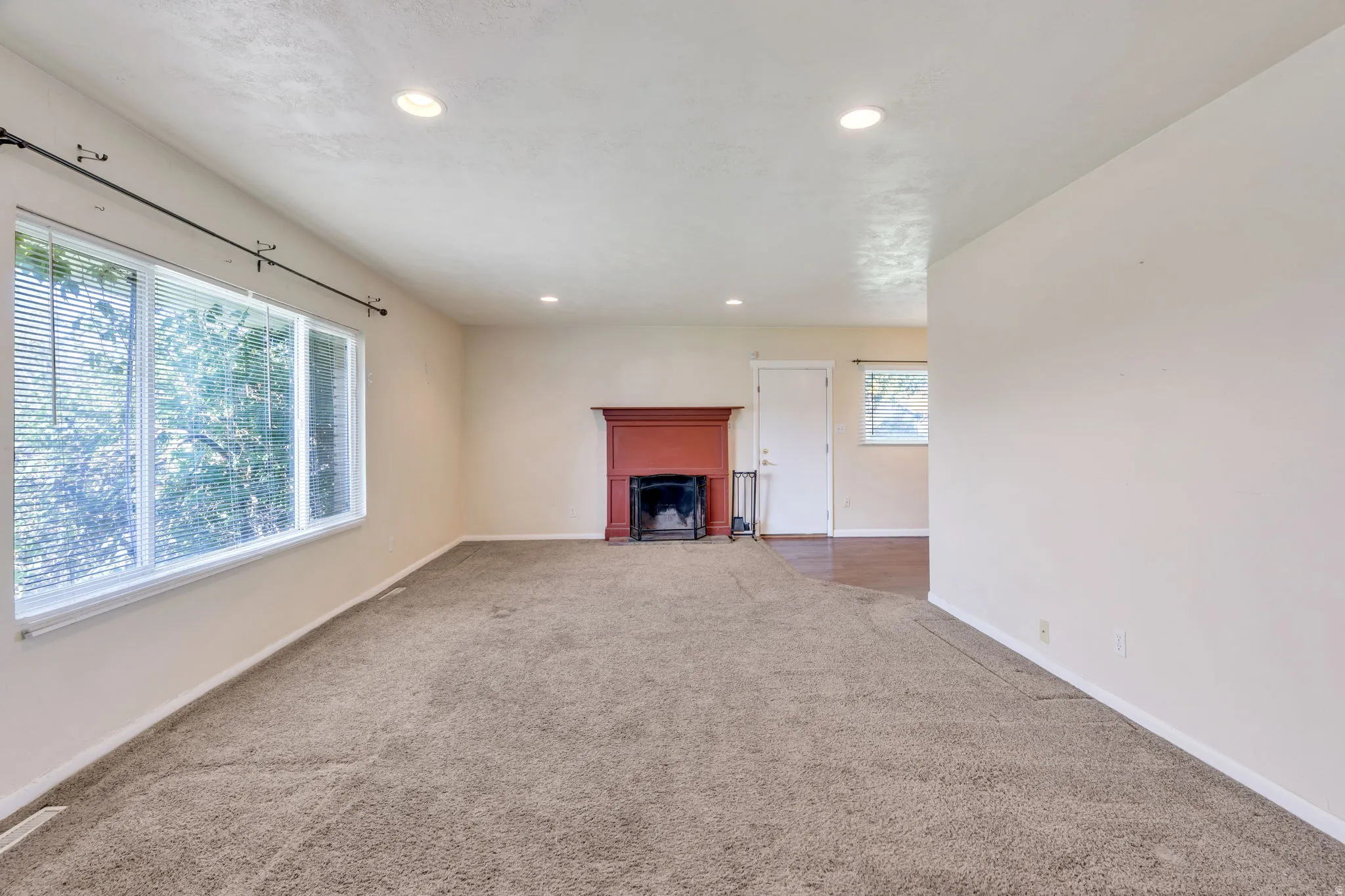 Recessed lighting, warm neutral wall tones, and a fireplace
