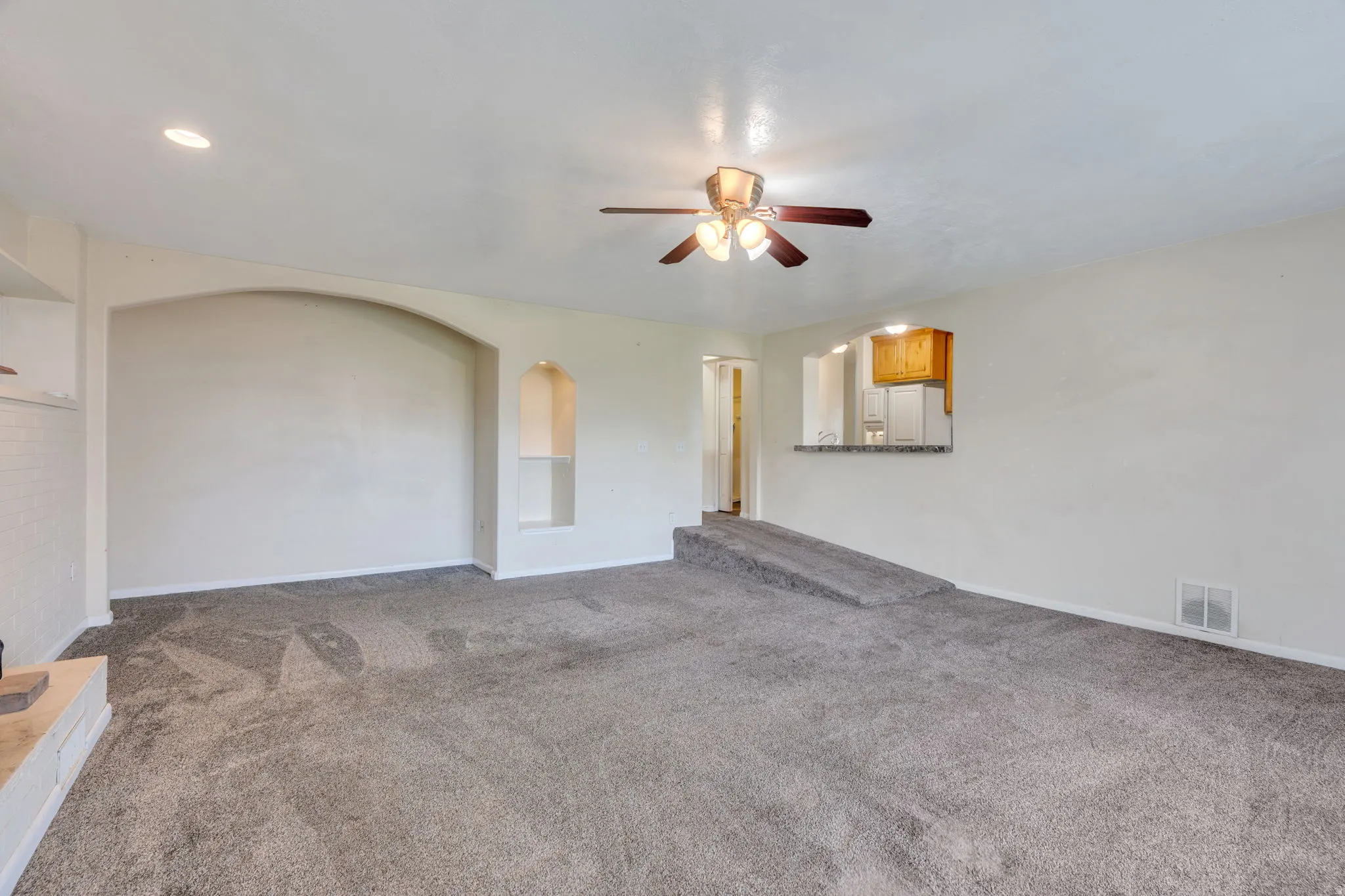 Spacious room with gray carpet, recessed lighting, and a ceiling fan