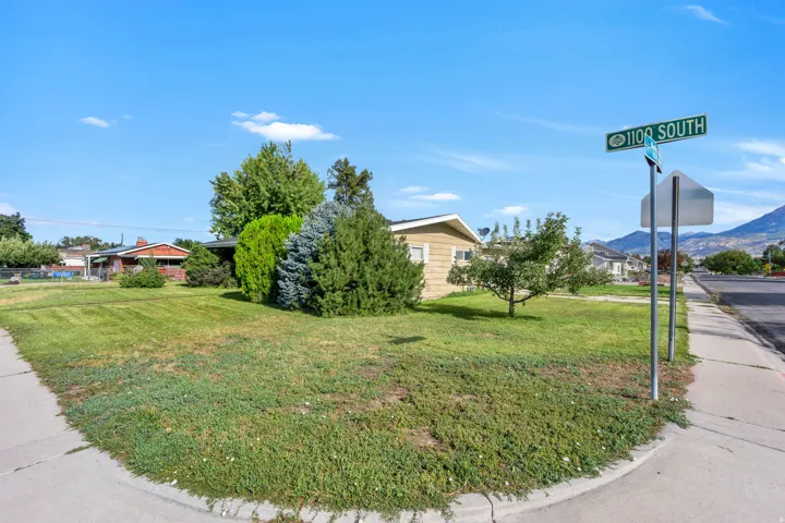 Expansive corner lot featuring a manicured lawn and mature trees
