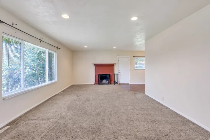 Recessed lighting, warm neutral wall tones, and a fireplace