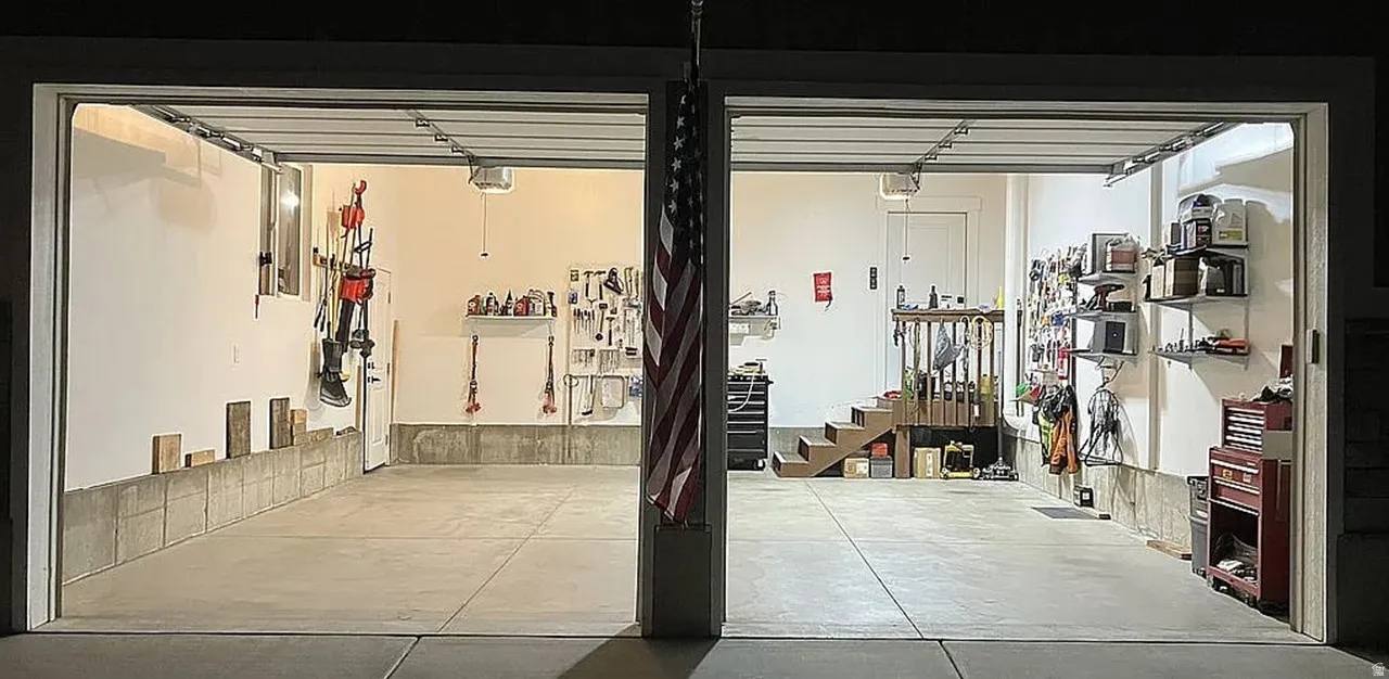 Concrete garage flooring with a two-bay layout, integrated lighting, and a partial staircase