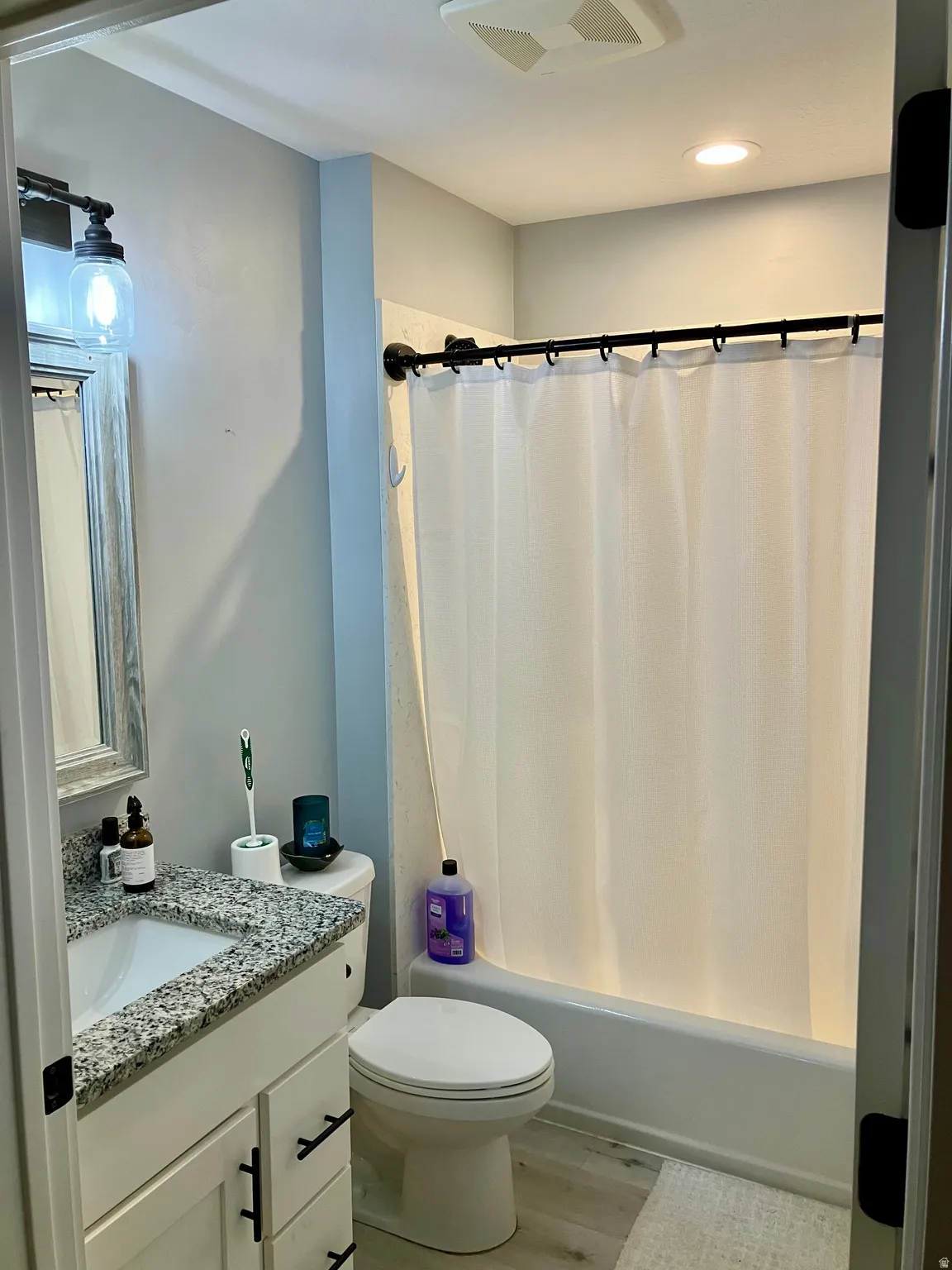 White vanity with granite-style countertop and integrated sink