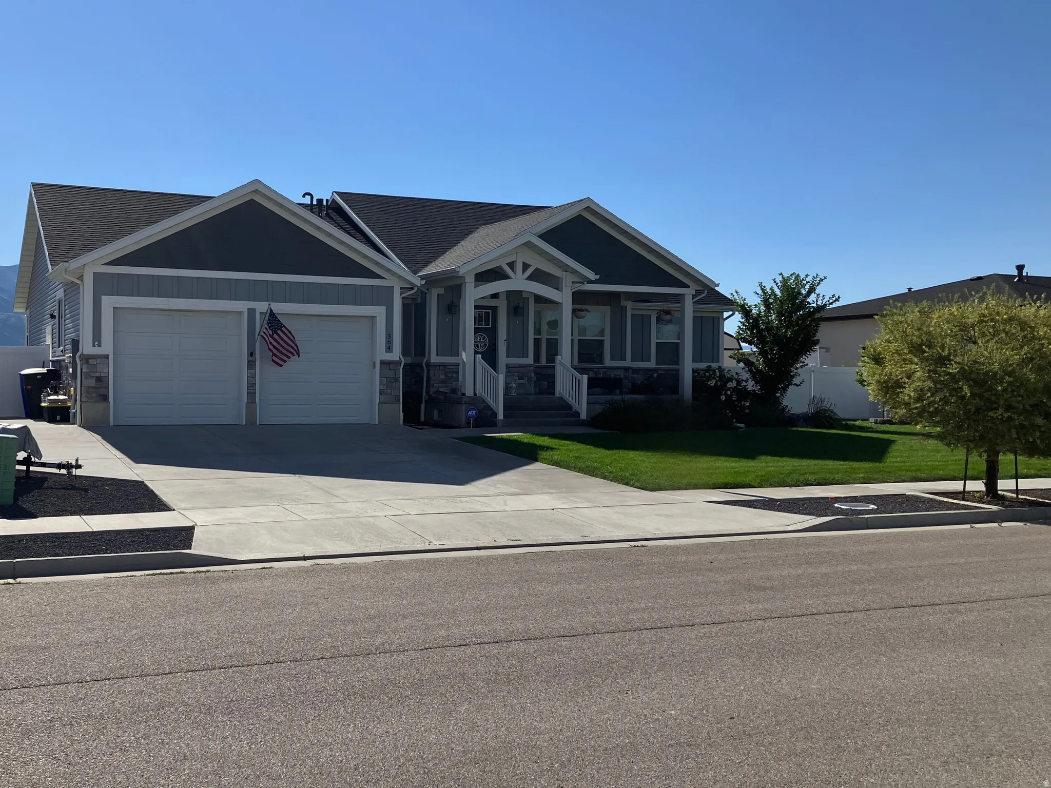 Exterior with light gray siding and stone accents