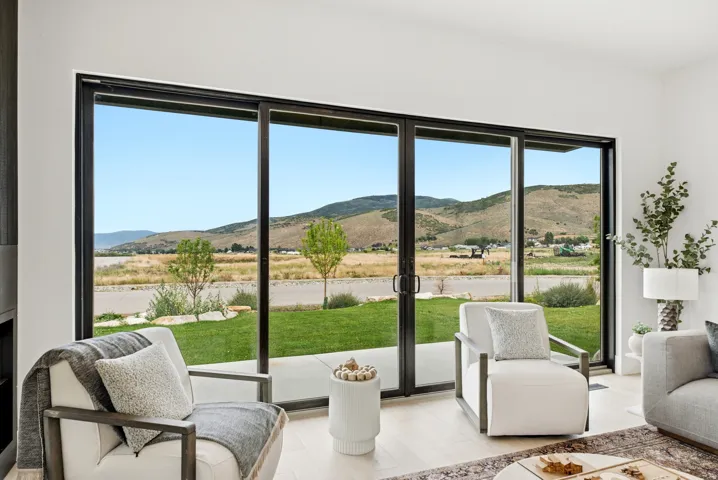 Expansive sliding glass doors, mountain scenery, and light wood-finish flooring