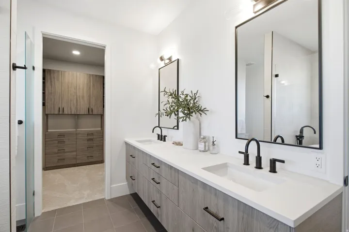 Dual vanity with white countertops and wood-finish cabinetry