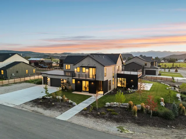 Modern architectural design with wood-finish siding, multiple balconies, and an attached two-car garage