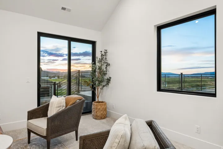 Vaulted ceiling, expansive sliding glass door, large picture window, and neutral wall finishes