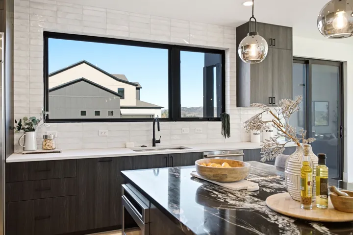 Modern kitchen featuring dark wood-finish cabinetry, white countertop, and a contrasting dark countertop island