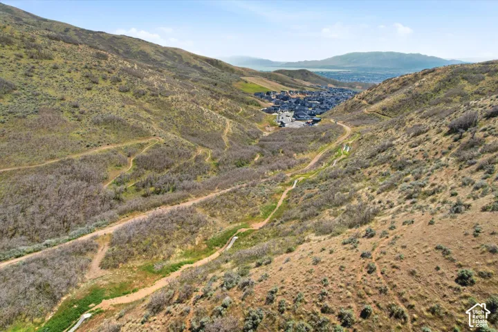 Rolling hills with established trails and distant residential structures