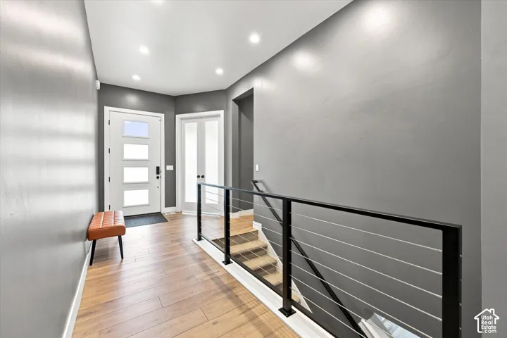 Foyer with wood-finish flooring, recessed lighting, and a modern white entry door