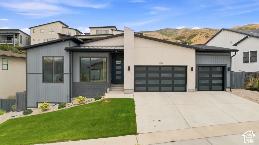 Contemporary architectural design featuring a two-car garage, an additional single-car garage, and a concrete driveway