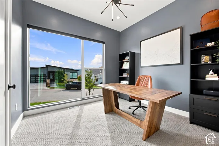 Expansive floor-to-ceiling window, light gray carpet flooring, dark gray wall paint, and a modern ceiling light fixture