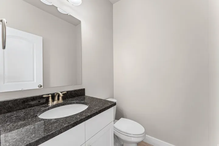 Vanity with dark speckled countertop, undermount sink, and brushed nickel faucet