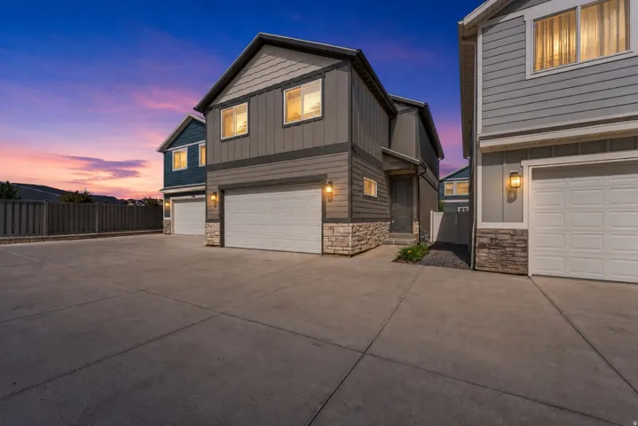 Contemporary exterior with board and batten siding, stone veneer accents, and an attached two-car garage