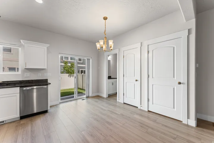 Light wood-finish flooring with white baseboards, featuring a sliding glass door to the exterior