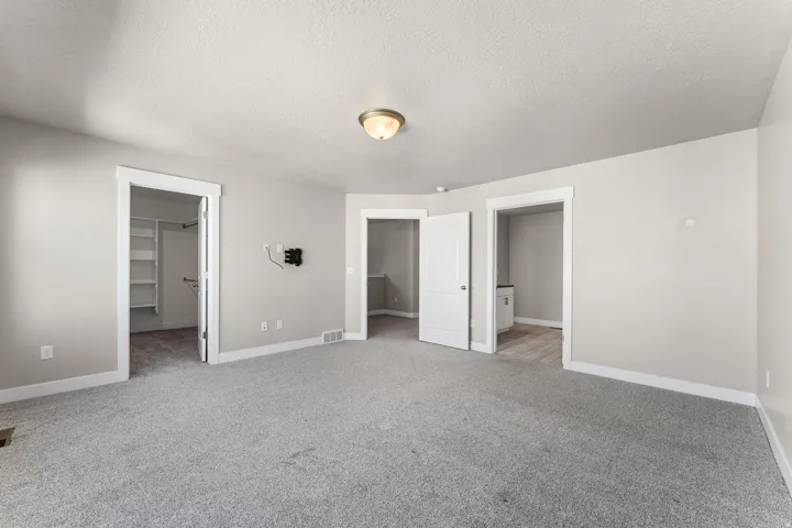 Neutral-toned walls complement the gray carpeting