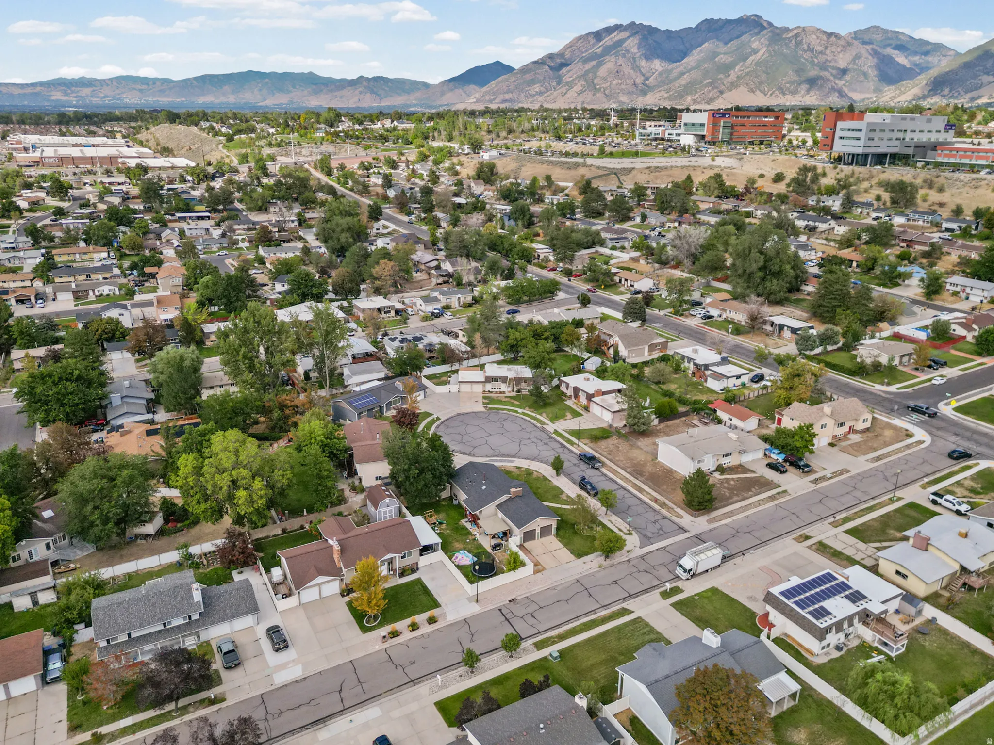 Residential neighborhood with mature trees and mountain backdrop