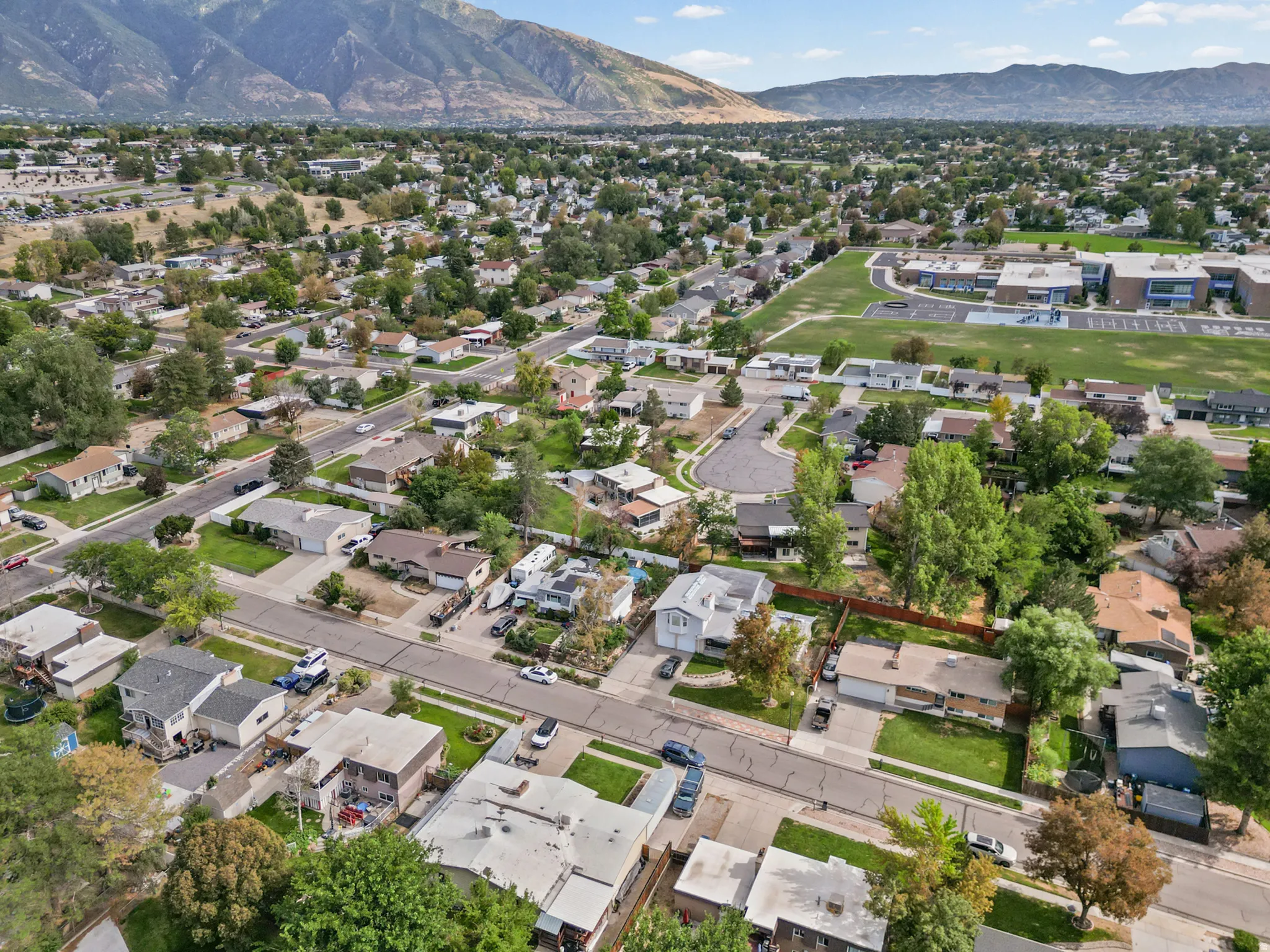 Expansive residential area with mature trees and mountain scenery