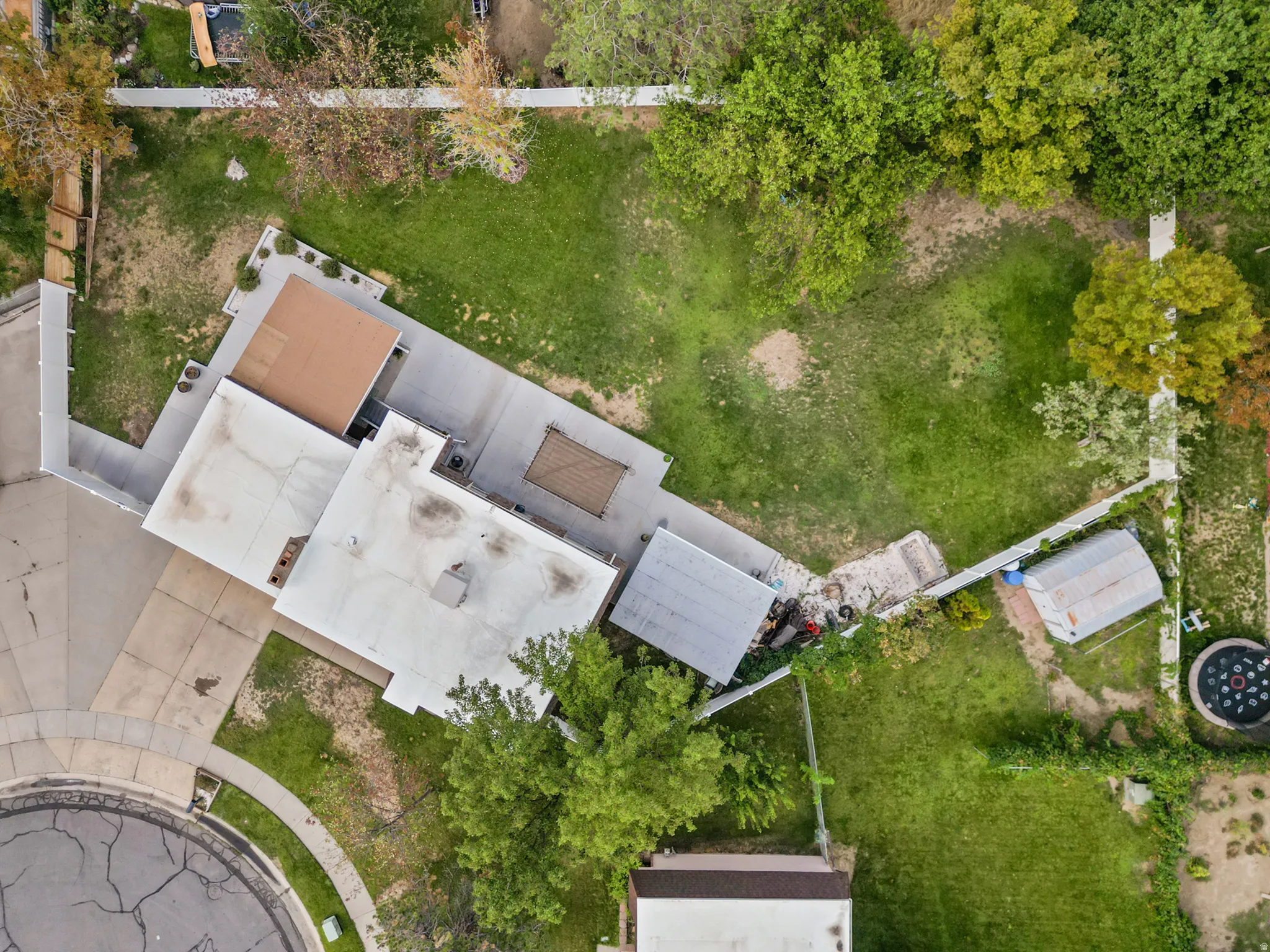 Spacious property with extensive green space, a paved patio area, and mature trees