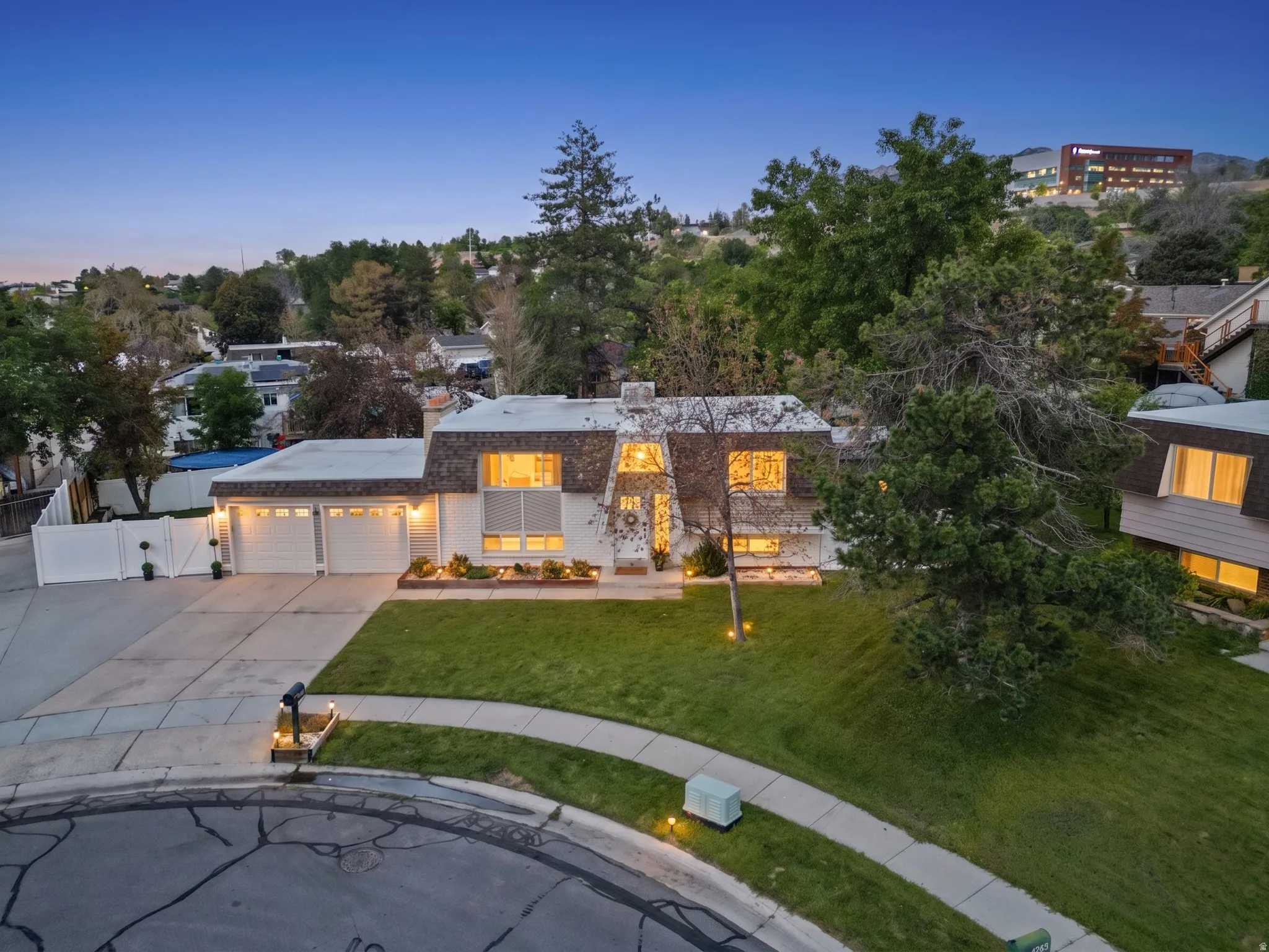 Stone facade exterior with a two-car garage, concrete driveway, and front lawn