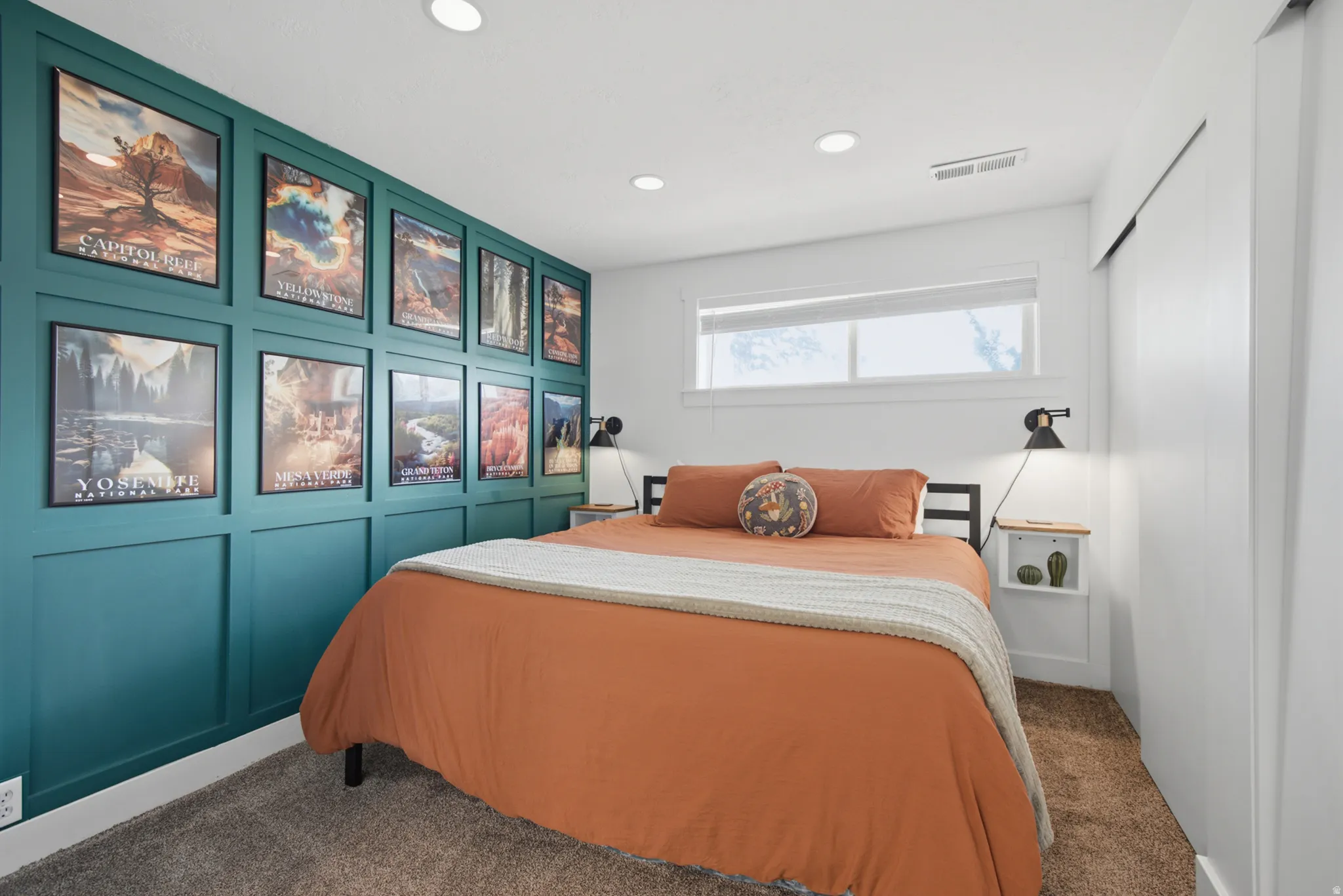 Feature wall with wainscoting and picture frame molding, recessed lighting, double window with roller shade, integrated wall sconce, and carpet flooring