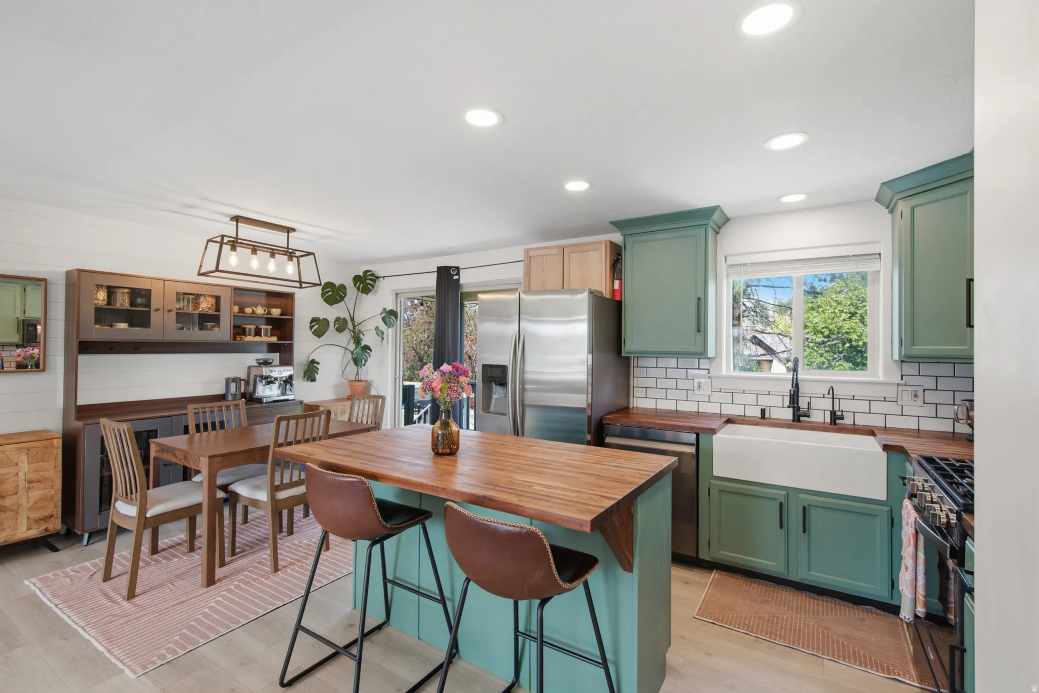 Kitchen featuring light wood-finish flooring, a farmhouse sink, stainless steel appliances, and wood countertops