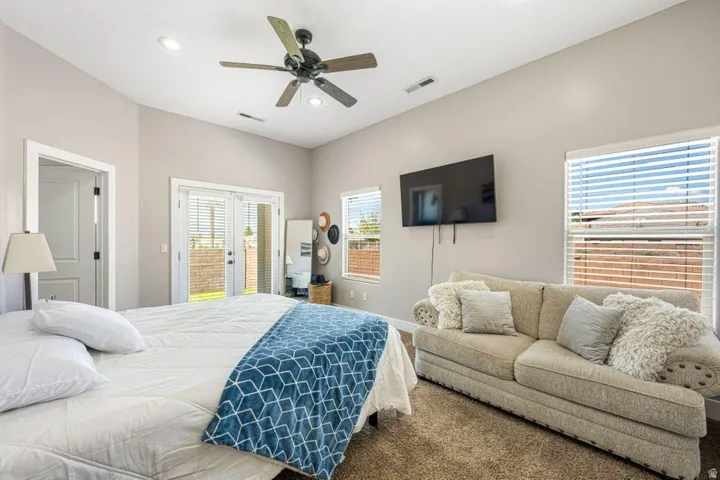 Vaulted ceilings with recessed lighting, ceiling fan, carpeted flooring, and glass-paneled double doors
