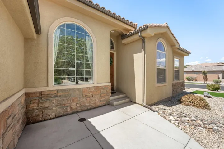 Stucco exterior featuring a stone accent façade and arched windows