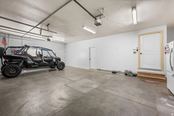 Concrete flooring, multiple access doors, overhead fluorescent lighting, garage door opener mechanism